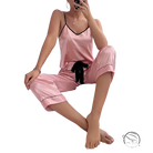 Pink satin pajama set with black trim, bow, and black eye mask