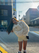 Short loose casual faux fur coat by Langry with cream fur, black trim, oversized design