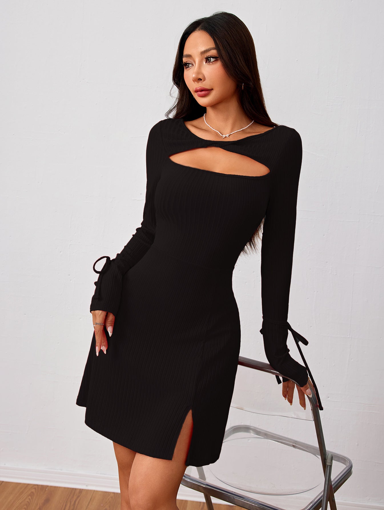 Black long-sleeved dress with cutout, side slit, and tie details in fashion ملابس style