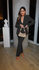 Woman in black suit with gold purse in casual professional pants two piece set
