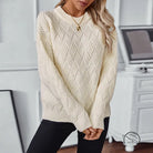 Cream herringbone crew neck knit sweater with black leggings and gold necklace