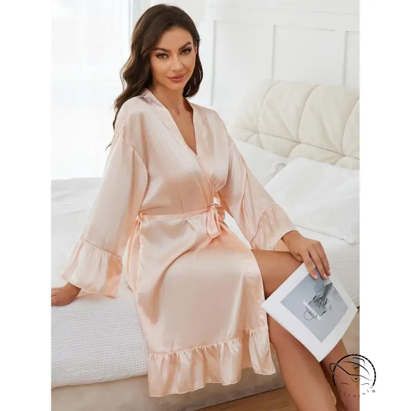 Woman in long sleeve peach satin ruffled robe nightgown