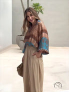 Elegant two piece set: woman in patterned blouse and wide-leg pants