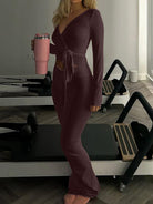 Woman in form-fitting maroon langry fashion wrap dress with cutout detail