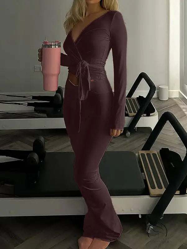 Woman in form-fitting maroon langry fashion wrap dress with side tie