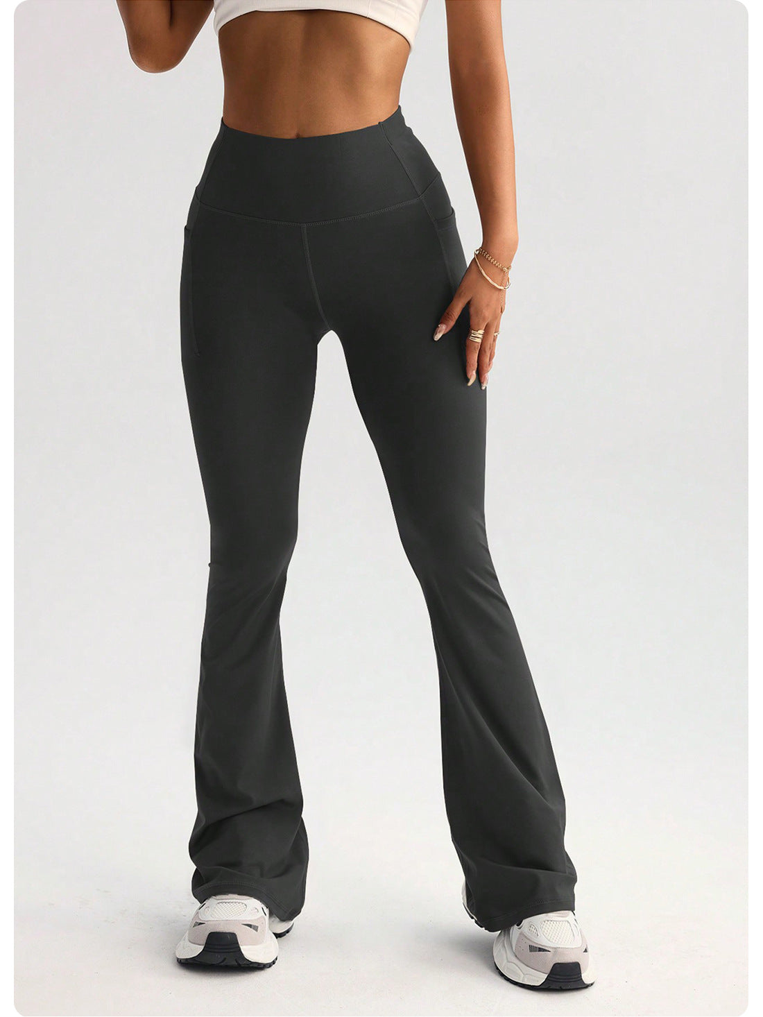 High-waisted dark gray flared langry yoga pants in stretchy fabric with side pockets