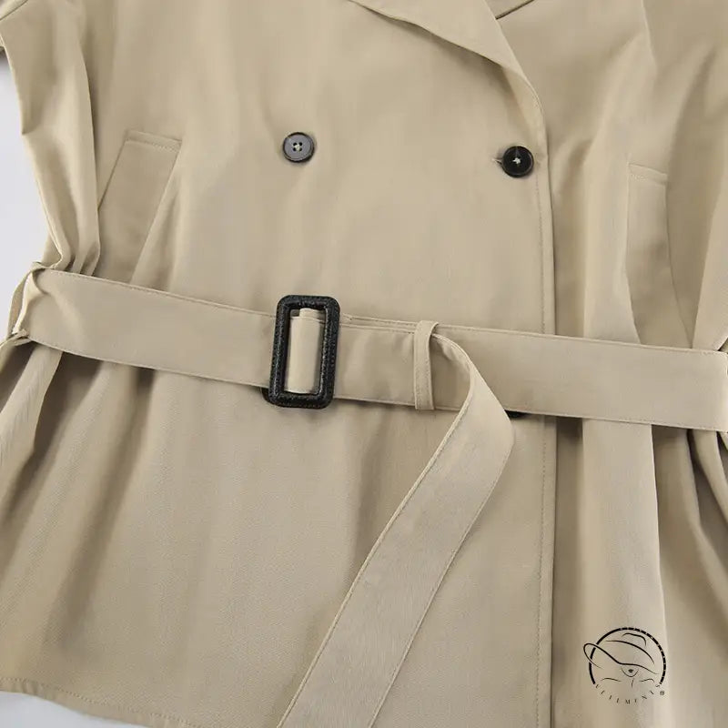 Beige trench coat with black buttons and belt buckle in British fashion style