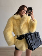 Yellow fluffy faux fur coat with black belt and Celine bag