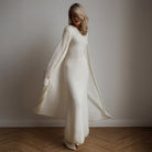 Cream-colored knitted cardigan sleeveless dress with long sleeves and flowing skirt