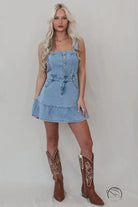 Office suspenders denim dress with light wash tiered skirt and cowboy boots