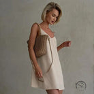 Woman in casual backless cotton home wear slip dress with straw bag