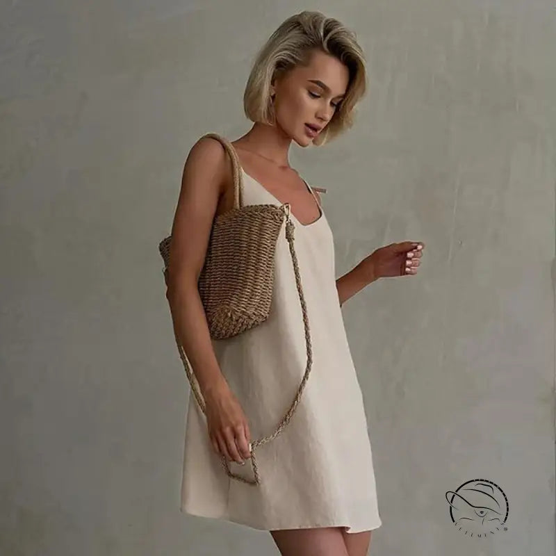 Woman in casual backless cotton home wear slip dress with straw bag