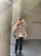 Beige faux fur oversized coat with leather accents and floral headband
