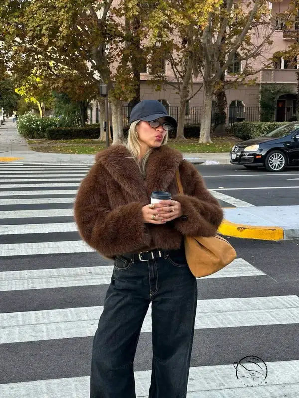 Gorgeous faux fur fox jacket with black belt, jeans, tan bag