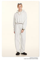 All-white sweatsuit ensemble featuring a hooded top and loose-fitting pants for winter fashion