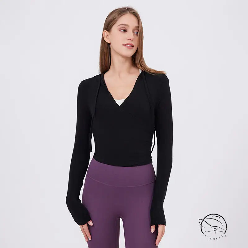 Slim fit slimming black long-sleeved hoodie with V-neck and side ties over white top