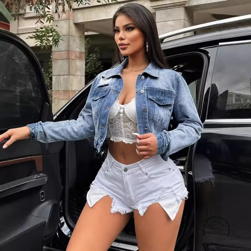 Woman in loose short denim coat with white lace top and shorts