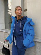 Woman in blue puffer jacket and matching tracksuit showcasing Langry fashion ملابس