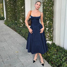 Woman in navy backless sling dress