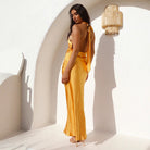 Yellow satin maxi dress with open back, halterneck, and shoulder straps