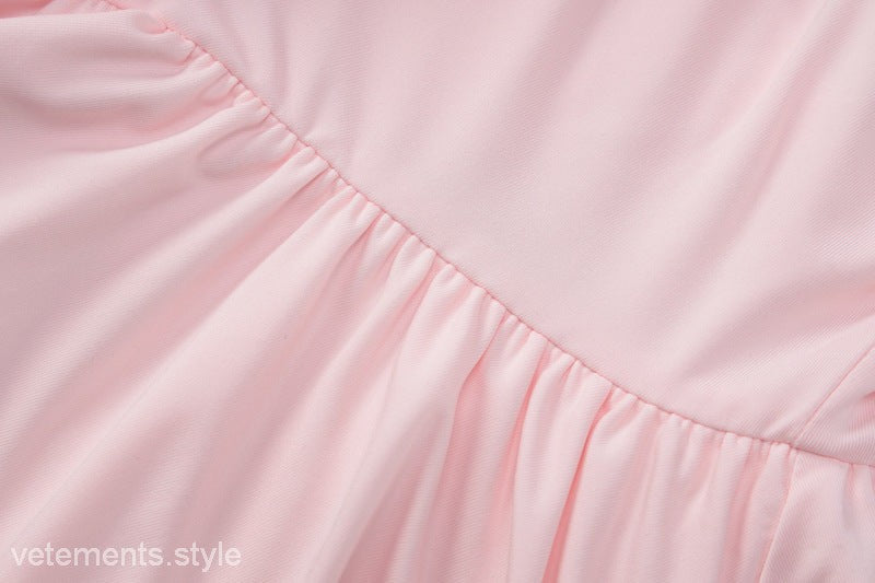 Pink gathered fabric on a sexy halter low cut ruffled dress for elegant evening wear