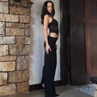 Elegant langry fashion mesh dress: model in black crop top and pants against wall