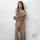 Woman in comfortable knitted pajamas set: brown long-sleeved top and wide-leg pants