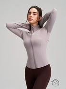 Long sleeve lavender yoga jacket with white accents and brown leggings