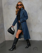 Woman in casual retro denim coat with belt, black outfit and handbag