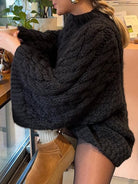 Black cable knit long sleeve oversized sweater with tan suede boots