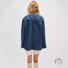 Woman in casual fashionable cowboy coat, denim jacket over ruffled dress