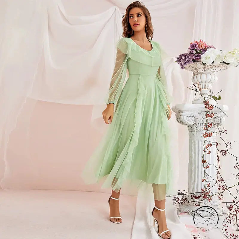 Woman in gorgeous high-waist A-line voile dress with sheer sleeves and ruffles