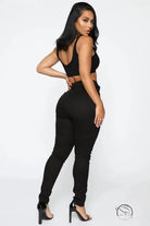 Woman in black crop top and casual skinny stretch belt sports pants
