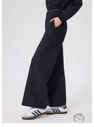 Black loose fitness warm pants with white Adidas sneakers and gold zipper