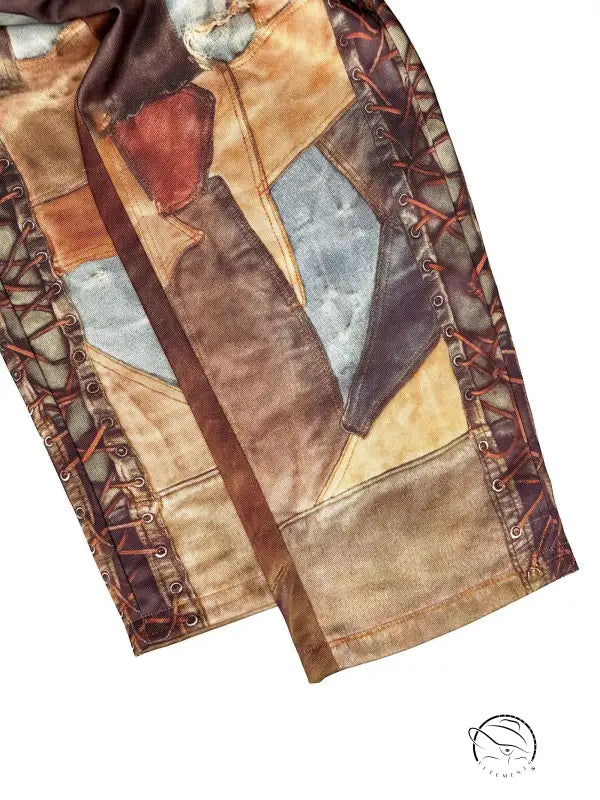 Patchwork leather jacket sleeve with brown, tan, blue geometric panels on casual dirty denim pants