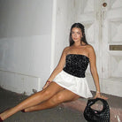 A woman in an Elegant off the Shoulder Short Dress on the floor, showcasing modern fashion