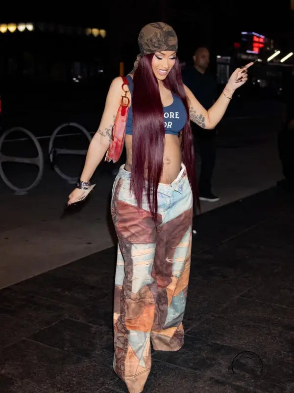 Person in casual dirty denim pants, crop top, and long purple hair