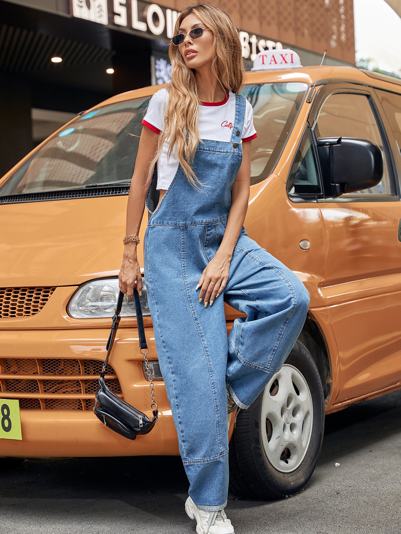 Denim overalls with a cropped t-shirt in a stylish casual denim jumpsuit for modern fashion