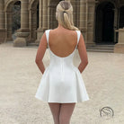 White backless langry mini dress with flared skirt and thin straps