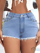 Slimming frayed beaded jeans shorts in light blue denim with raw hem and studded pockets
