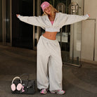 Langry fashion black handbag with pink earmuffs and keychain on hooded jacket trousers suit