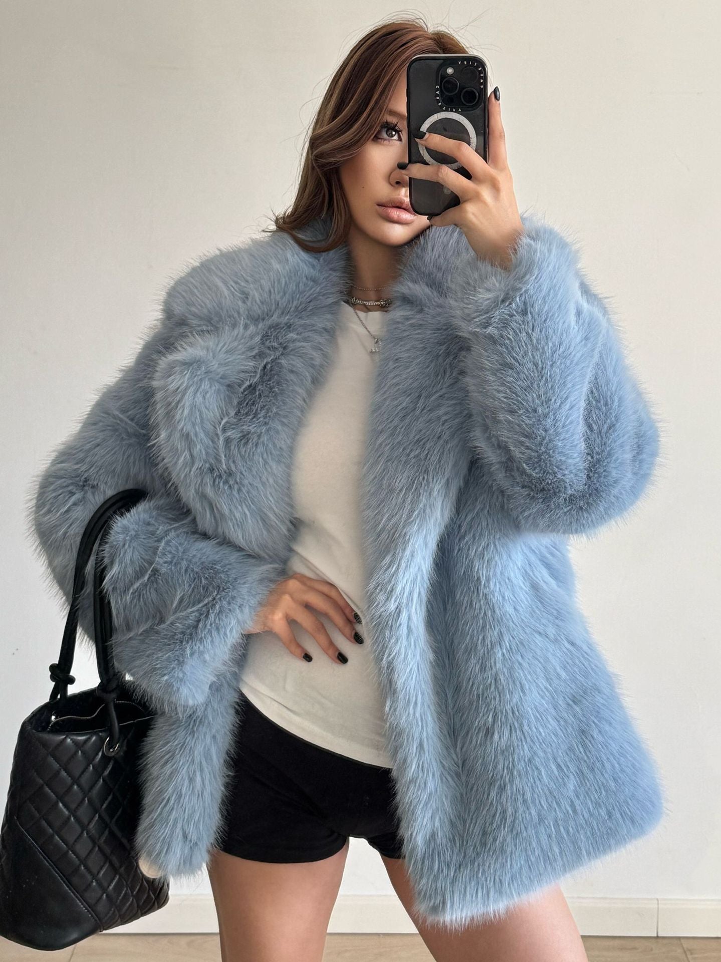 Light blue faux fur Langry fashion coat with black quilted handbag