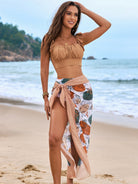 Person in fringed brown bikini top and floral sarong at beach, showcasing Gorgeous Split Bikini fashion