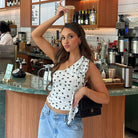 Polka dot white crop top with black dots, denim jeans and purse by Langry Fashion