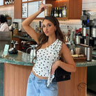 Polka dot white crop top with black dots, denim jeans and purse