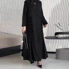 Black long-sleeved trench coat with ruffled hem and button detail