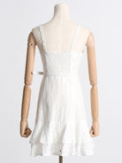White lace sundress on mannequin, showcasing spaghetti straps and stylish smocked bodice