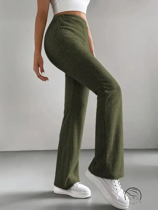 Person in casual knitted match pants: ribbed dark green wide-leg style with white sneakers