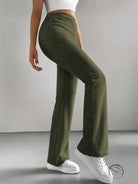 Person in casual knitted match pants: ribbed dark green wide-leg style with white sneakers