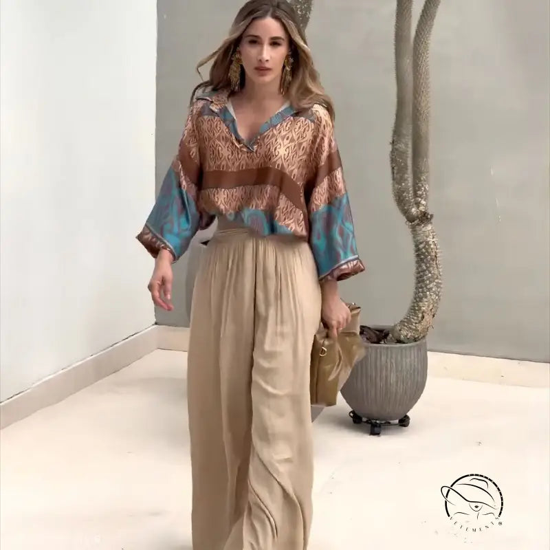Woman in elegant two piece set with patterned blouse and wide-leg pants